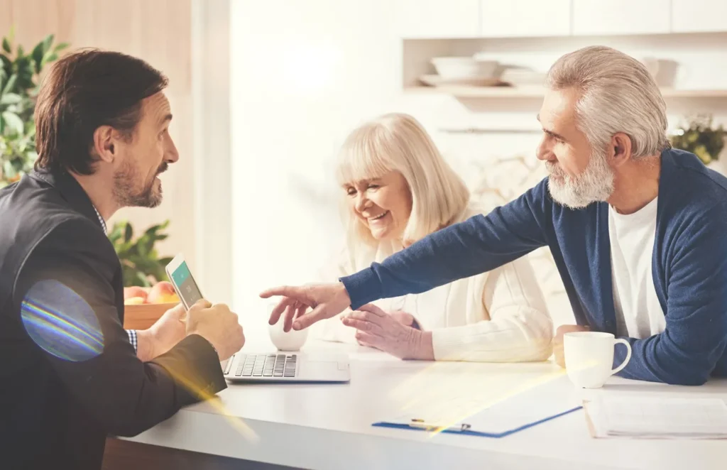 An attorney speaking with his clients showing them something on the computer.