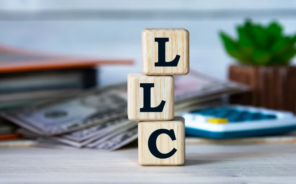 Wooden blocks spell out the word LLC.